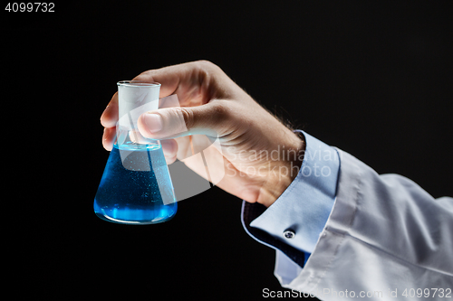 Image of close up of scientist holding flask with chemical