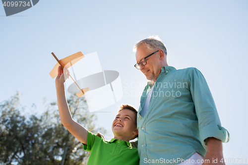 Image of senior man and boy with toy airplane over sky