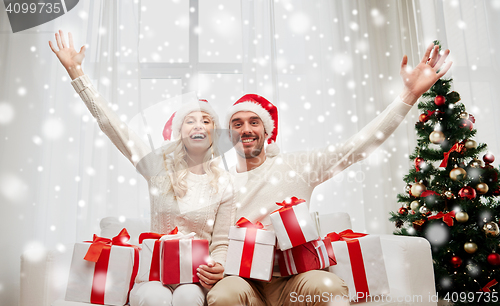 Image of happy couple at home with christmas gift boxes