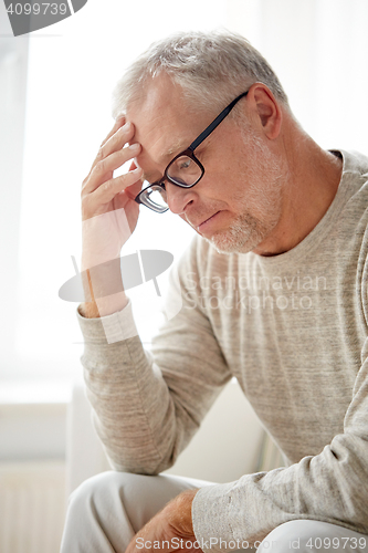 Image of senior man suffering from headache at home