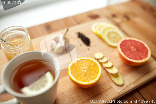 Image of ginger tea with honey, citrus and garlic on wood