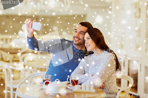 Image of couple taking smartphone selfie at cafe restaurant