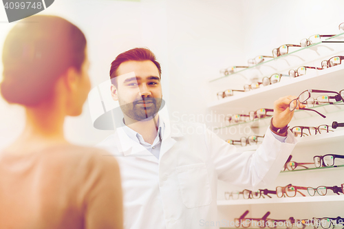 Image of woman and optician showing glasses at optics store