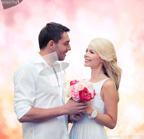 Image of happy couple with flowers over lights background