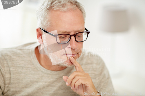 Image of close up of senior man in glasses thinking