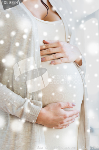 Image of close up of pregnant woman belly and hands