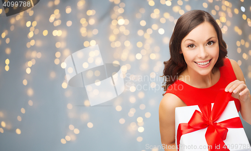 Image of smiling woman in red dress with gift box