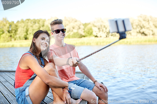 Image of happy teenage couple taking selfie on smartphone