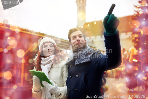 Image of happy couple walking with tablet pc in old town