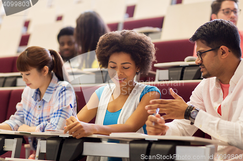 Image of group of students with notebooks in lecture hall