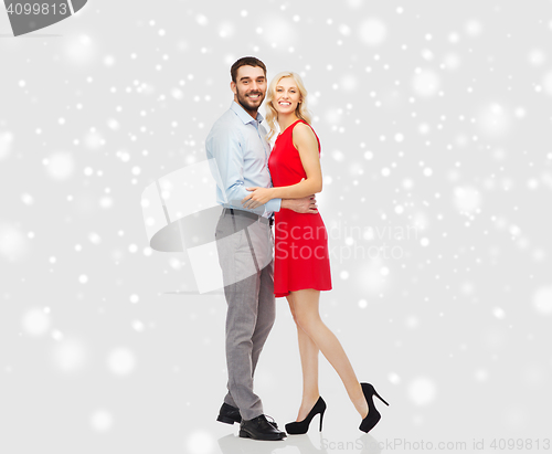 Image of happy couple hugging over snow background