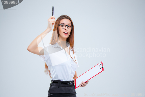 Image of The young business woman with pen and tablet for notes on gray background