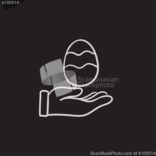 Image of Hand holding easter egg sketch icon.