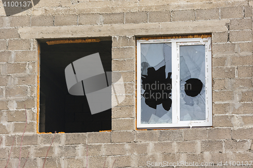 Image of Anapa, Russia - November 16, 2016: Two windows in an unfinished house - one without a frame and glass, the other broken glass