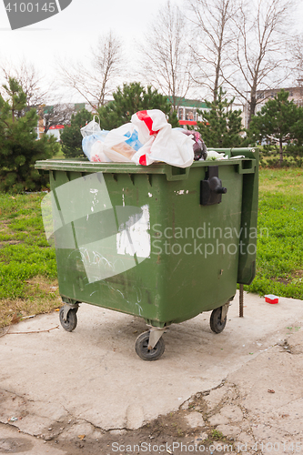 Image of The garbage container on wheels completely packed with trash