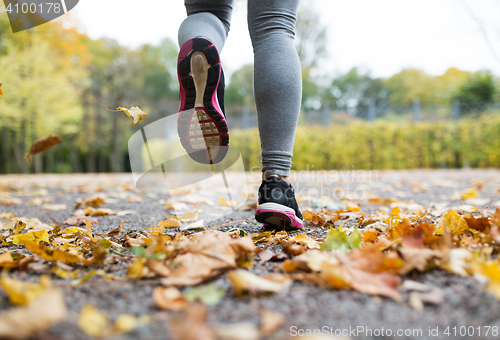 Image of close up of young woman running in autumn park