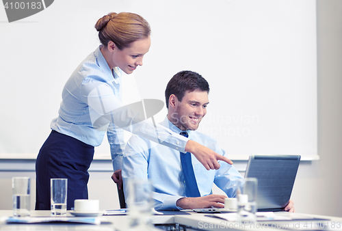 Image of businessman and secretary with laptop in office