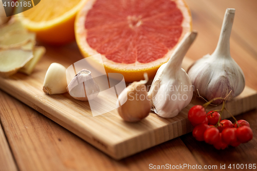 Image of citrus, ginger, garlic and rowanberry on wood