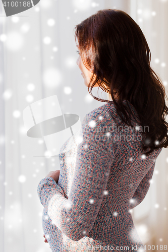 Image of close up of happy pregnant woman looking to window