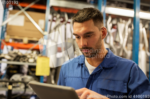 Image of auto mechanic or smith with tablet pc at workshop