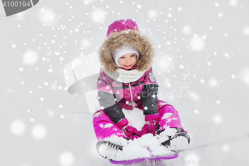 Image of happy little kid on sled outdoors in winter