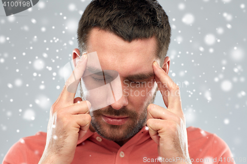 Image of man suffering from head ache or thinking over snow