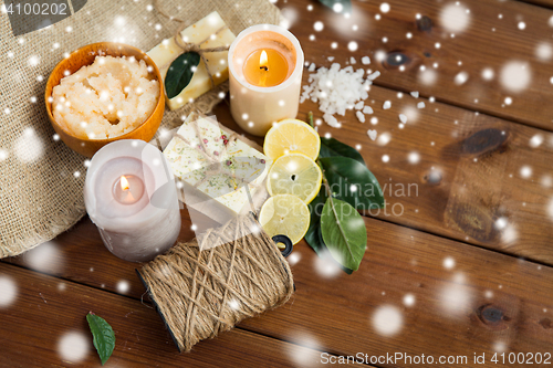 Image of natural soap and body scrub with candles on wood