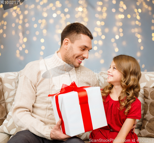 Image of smiling father and daughter with christmas gift