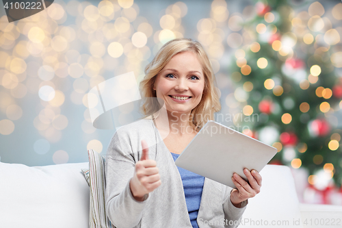 Image of happy woman with tablet pc showing thumbs up