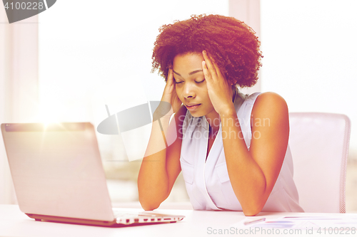 Image of african woman with laptop at office