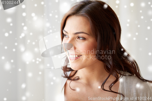 Image of close up of happy woman looking through window