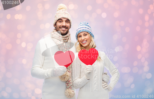 Image of smiling couple in winter clothes with red hearts