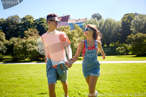 Image of happy teenage couple walking at summer park