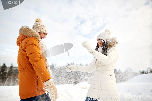 Image of happy couple playing with snow in winter