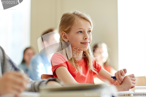 Image of group of students with notebooks at school lesson