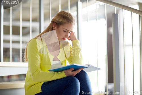 Image of high school student girl reading book on stairs