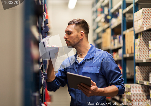 Image of auto mechanic or smith with tablet pc at workshop