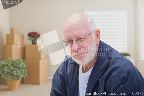 Image of Senior Man in Empty Room with Packed Moving Boxes