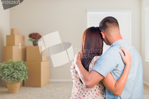 Image of Military Couple Facing Empty Room with Packed Moving and Potted 