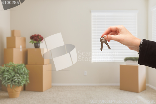 Image of Handing Over House Keys In Room with Packed Moving Boxes