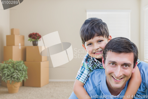Image of Father and Son in Room with Packed Moving Boxes and Potted Plant