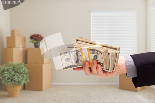 Image of Handing Over Cash In Room with Packed Moving Boxes