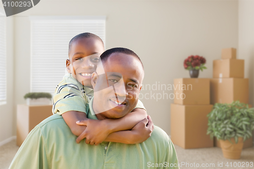 Image of African American Father and Son In Room with Packed Moving Boxes