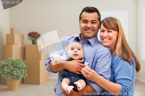 Image of Mixed Race Family with Baby in Room with Packed Moving Boxes