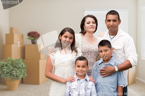 Image of Hispanic Family in Empty Room with Packed Moving Boxes and Potte