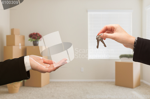 Image of Handing Over House Keys In Room with Packed Moving Boxes