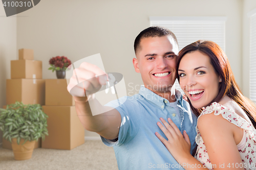 Image of Young Military Couple with House Keys in Empty Room with Packed 