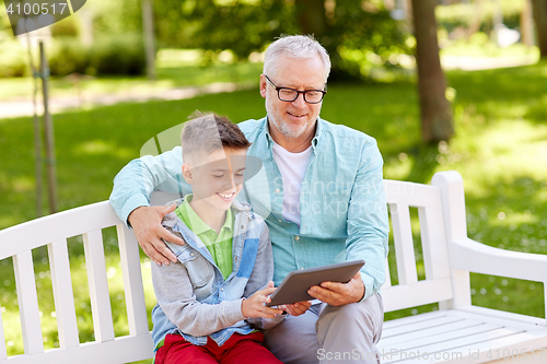 Image of grandfather and boy with tablet pc at summer park