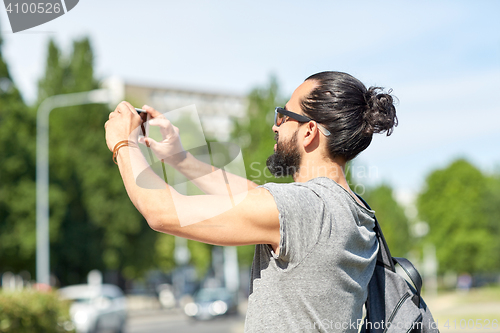 Image of hipster man taking picture on smartphone