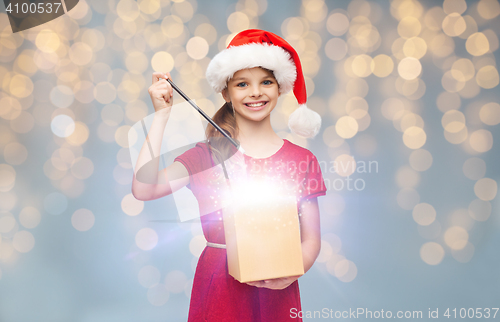 Image of girl in santa hat with gift box and magic wand